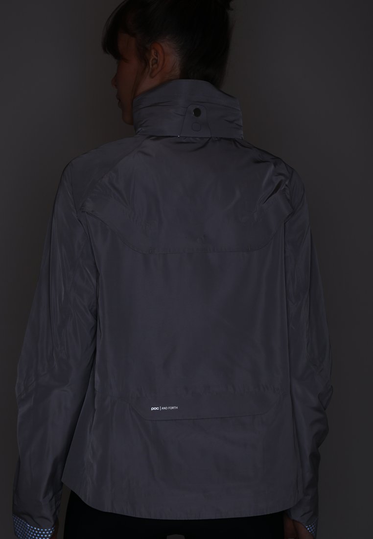 Graue, leichte Jacke mit hohem Kragen, schlankem Design und dezentem Logo auf der Rückseite. Glatte Textur mit minimalen Details.