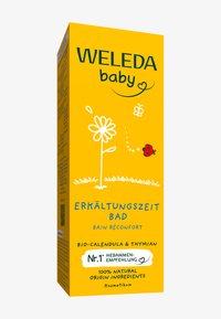 Scatola gialla per il prodotto Weleda Baby, etichettata "Erkältungszeit Bad". Presenta illustrazioni di fiori e un coccinella, con testo in blu e verde.