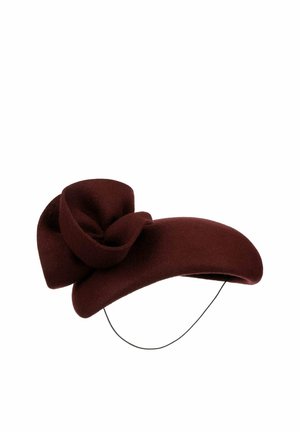Dark maroon felt hat with exaggerated asymmetrical brim and large decorative bow, featuring a thin black chin strap.