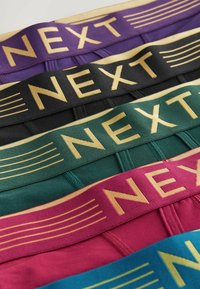 Fünf Paare Herrenunterwäsche mit elastischen Bündchen in Lila, Schwarz, Grün, Burgunderrot und Türkis, mit goldener "NEXT"-Markierung.