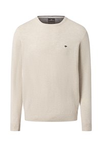 Beżowy sweter z dzianiny z długimi rękawami, okrągłym dekoltem i ma�łym ciemnym logo na piersi. Miękka tekstura, standardowy krój, ściągacze u dołu i na rękawach.