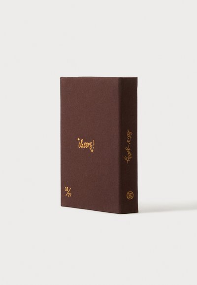 Livre rectangulaire marron foncé avec du texte doré indiquant "cheers!" sur la couverture et "let’s party" sur la tranche, sur un fond blanc uni.