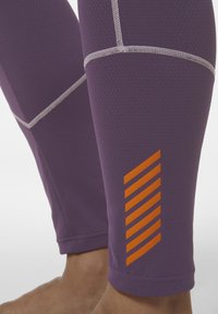 Paarse sportleggings met een textuurstof, contrasterende grijze stiksels en een oranje gestreepte grafiek op het onderbeen.