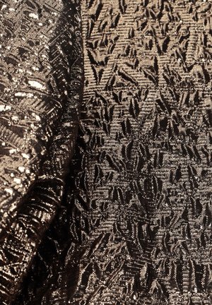 Strukturiertes Gewebe in Schattierungen von Dunkelbraun und Gold, mit einem Muster erhabener geometrischer Formen und einem metallischen Glanz. Weiches und flexibles Material.