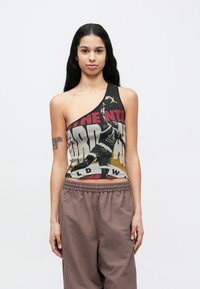 Débardeur asymétrique noir avec un imprimé graphique en rouge, jaune et blanc. Confectionné dans un tissu doux, avec une coupe sportive et des détails accentués.