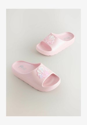 Różowe plastikowe klapki na obcasie z otwartym noskiem, ozdobione błyszczącym, tęczowym akcentem w kształcie muszli na wierzchu. Gładka faktura i wytrzymała podeszwa.