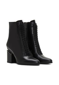 Botas de cuero negro hasta el tobillo con puntera afilada, cremallera lateral y detalles de cordones verticales en la parte delantera; tacón cuadrado.