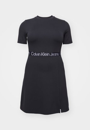 Robe noire à manches courtes en maille avec col ras-du-cou et ceinture élastique siglée Calvin Klein Jeans, avec une petite fente latérale sur la jupe.