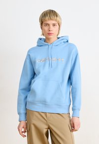 Hanorac bleu deschis, realizat dintr-un material moale, dotat cu o buzunar tip cangur și un logo pe față de culoare aurie. Croială lejeră cu manșete și tiv ondulate.