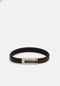 Brown leather bracelet featuring a silver-tone clasp with a black HILFIGER tag, textured surface, and two raised leather stripes.
