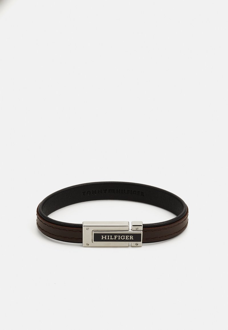 Brown leather bracelet featuring a silver-tone clasp with a black HILFIGER tag, textured surface, and two raised leather stripes.