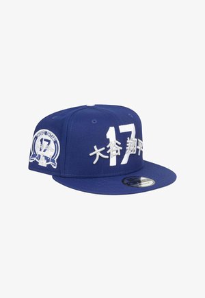 Blue snapback cap with white embroidered text "17" and symbols. Features a structured body, flat brim, and adjustable strap.