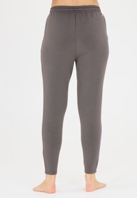 Graue, enganliegende Leggings mit einem elastischen Bund, nahtlosem Design und glatter Textur, die für Komfort und Flexibilität gestaltet sind und keine sichtbaren Beschläge aufweisen.