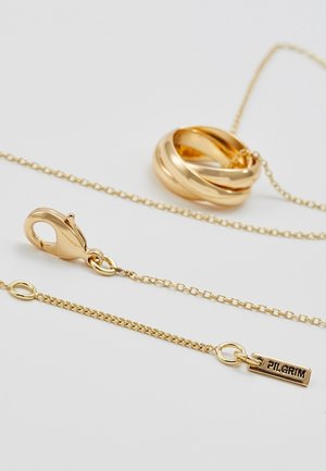 Gouden ketting met een gedraaid rond hangertje en een sluiting, met een klein labeltje gegraveerd met het woord "PILGRIM."