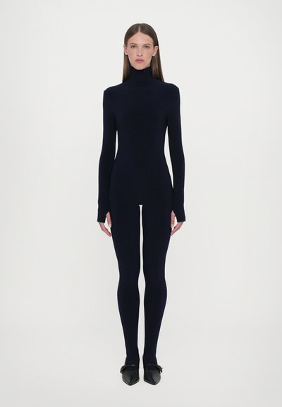 Granatowy bodysuit z wysokim kołnierzem, długimi rękawami i dopasowanym krojem. Materiał jest gładki o matowym wykończeniu. Noszony z czarnymi szpilkami.