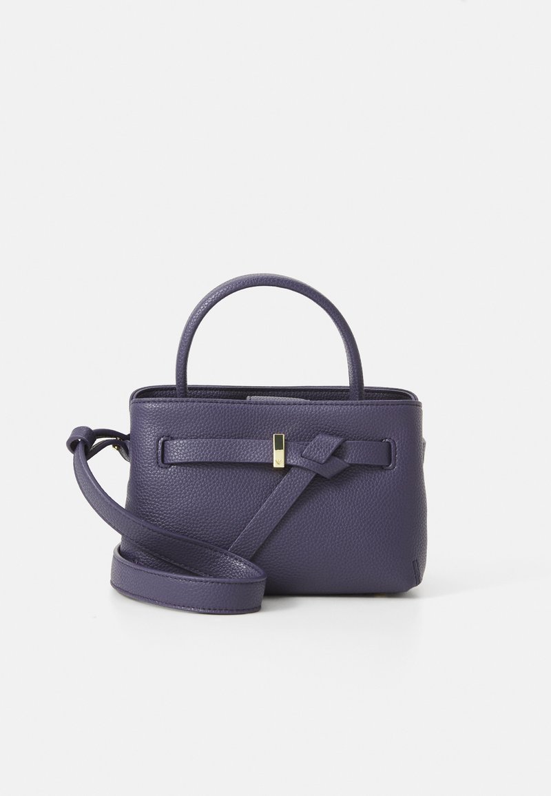 Mala de couro texturizado roxa com uma pega superior, alça de ombro ajustável e detalhe de faixa na frente com um pequeno fecho dourado.