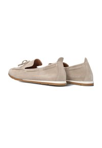 Lichtbeige suède loafers met een ronde neus, decoratieve strik en zijaccenten, witte tussenzool en rubberen buitenzool. Gladde textuur.