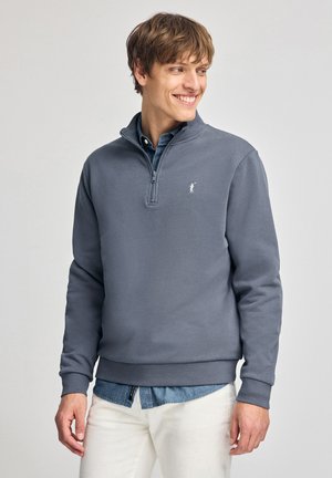 Grauer Reißverschluss-Hoodie aus weichem Material, mit Stehkragen, gerippten Bündchen und einem weißen gestickten Logo auf der linken Brust.