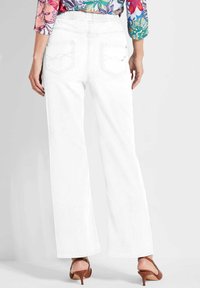 Witte wijde jeans met een aansluitende taille en achterzakken. De stof heeft een gladde textuur, aangevuld met een casual, relaxte pasvorm.