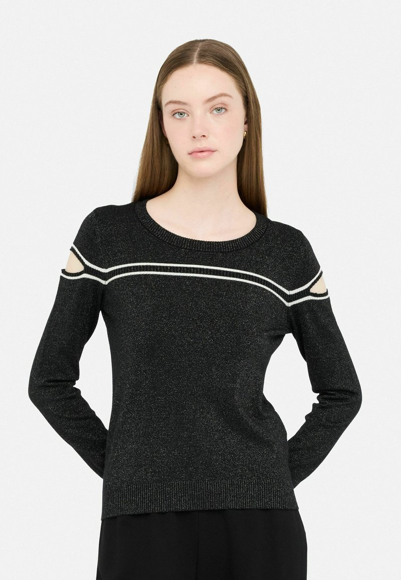 Schwarzer Pullover mit ausgeschnittenen Schultern und weißen Akzentstreifen. Hergestellt aus einem strukturierten Material mit subtiler glänzender Optik. Gerippter Halsausschnitt und Saum.