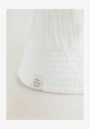 Weißer Baumwollbaskenmütze mit strukturiertem Gewebe, ausgestattet mit einem aufgenähten Etikett, das in sanftem Gold auf "Hallo, Kleines" lautet.