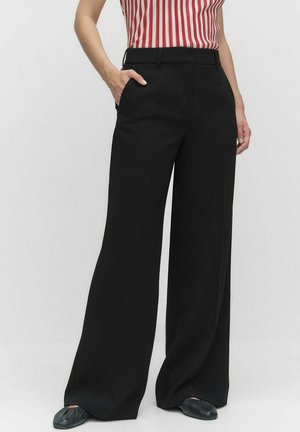 Schwarze, weit geschnittene Hose mit einer glatten, maßgeschneiderten Textur; verfügt über seitliche Taschen und ein flaches Vorderdesign. Getragen mit einem gestreiften roten Oberteil.