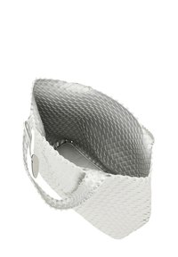 Bolsa de mano tejida blanca con forma estructurada, que presenta un interior suave y un asa resistente. Destaca por sus líneas limpias y superficie texturizada.