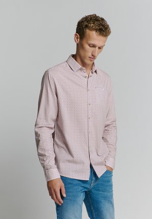 Lichtroze button-up shirt met een geometrisch patroon, lange mouwen en een borstzak. Draagt met blauwe jeans, uitgevoerd met een klassieke kraag.