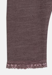 Leggings tricotate maro cu un model texturat. Prezintă un tiv ondulat împodobit cu un accent strălucitor pentru un plus de detaliu.