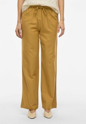 Wide-leg trousers in mustard yellow fabric, featuring an elastic waistband with a drawstring and a smooth texture.