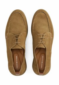 Suède tan schoenen met een ronde neus, stikselaccenten en vetersluiting. Logo gebosst op de binnenzool, gestructureerde rubberen buitenzool.