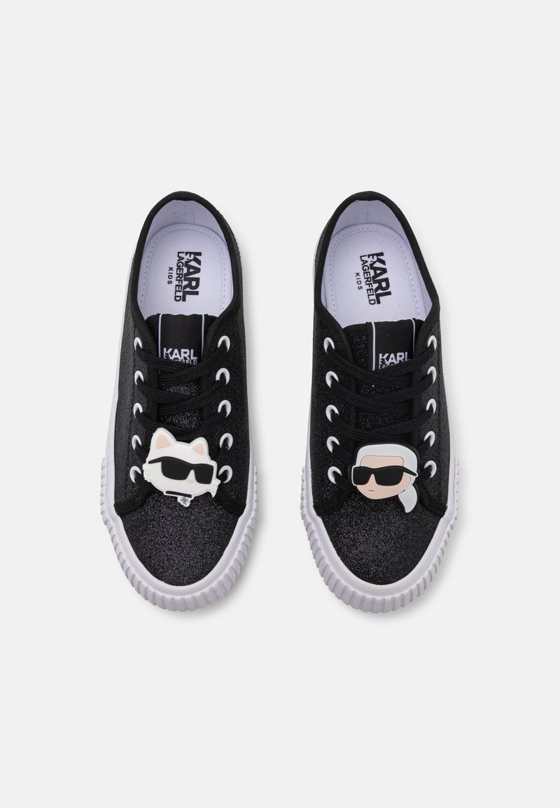 Μαύρα γκλίτερ αθλητικά παπούτσια με λευκές καουτσούκ σόλες, με πλαστικά charms σε σχήμα γάτας και γυαλιών ηλίου στα κορδόνια. Βαμβακερή επένδυση και μαξιλαρωτή σόλα.