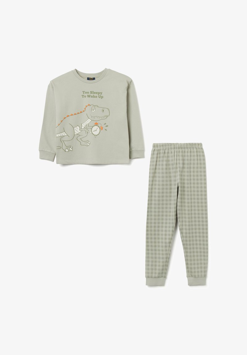 Groene pyjamaset met een langemmouw top met een dinosaurusafbeelding en de tekst "Te Slaperig Om Wakker Te Worden", gecombineerd met geblokte broeken.