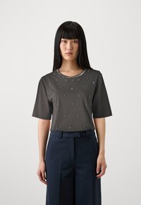 Tumši pelēks īsās piedurknes tops ar noapaļotu dekoltē, rotāts ar mazām dekoratīvām detaļām, apvienots ar tumši ziliem plats kāju biksēm.