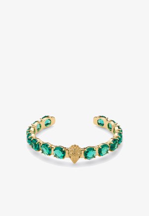 Goudkleurige armband met groene edelstenen, een schelpvormig accent in het midden en een gladde, gepolijste afwerking.