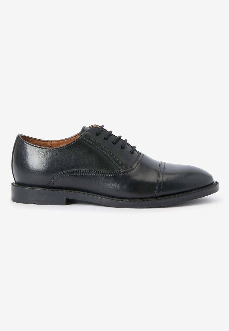Chaussure oxford en cuir noir à finition lisse, bout arrondi, lacets à cinq œillets et détails de couture subtils sur la tige.