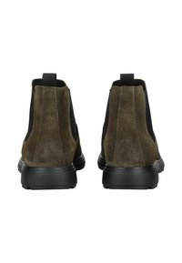 Botas de tobillo de ante marrón con paneles elásticos negros, una lengüeta y una suela de goma negra. Textura suave con una paleta de colores apagados.