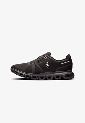 Chaussures de sport noires avec tige en mesh, col rembourré et logo contrastant ; elles disposent d'une semelle segmentée avec des éléments de coussinage pour un maintien optimal.