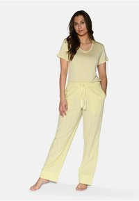 Lichtgele pyjama set met een kortemouwen top met ruches en bijpassende relaxed-fit broek met een koord in de taille en textuurstof.