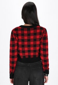 Rot-schwarz kariertes Strickpullover mit langen Ärmeln und rundem Ausschnitt, mit einem gerippten schwarzen Saum und Bündchen.