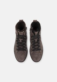 Para szarych zamszowych butów zimowych z czarnymi sznurówkami i futrzanym wykończeniem, widziana z góry na jednolitym białym tle.