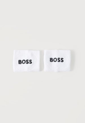 Dos pulseras blancas con texto bordado en negro "BOSS" colocadas lado a lado sobre un fondo claro.