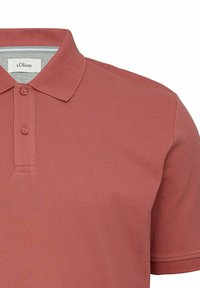 Poloshirt mit kurzen Ärmeln in Terrakottafarbe, ausgestattet mit einem klassischen Kragen, einer zwei-knöpfigen Knopfleiste und dezentem s.Oliver-Logo auf der Brust.