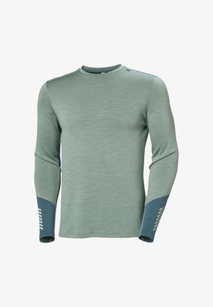 Hedvábná halenka s dlouhými rukávy vyrobená z texturované světle zelené látky. Rukávy mají tmavě modré akcenty s bílými pruhy a kulatý výstřih.