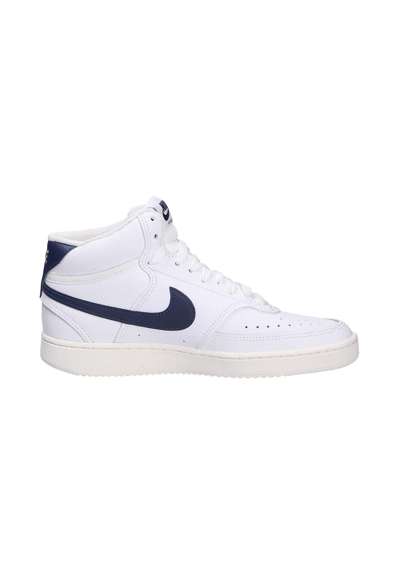 Sneaker alte bianche in pelle con un accento blu navy sul tallone e il classico logo swoosh della Nike. Superficie texturizzata e perforazioni visibili.