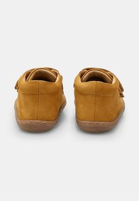 Chaussures en daim beige avec un design à chevilles basses, dotées d'un bout rond, d'une doublure douce et d'une semelle en caoutchouc flexible. Pas de matériel visible ni d'ornements.