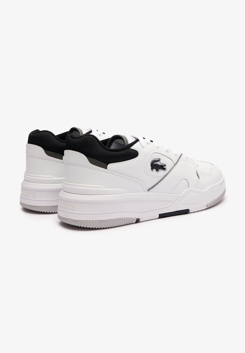 Baskets en cuir blanc avec des accents en maille noire. Semelle épaisse, motif texturé sur la semelle extérieure, et un détail de logo discret sur le côté.