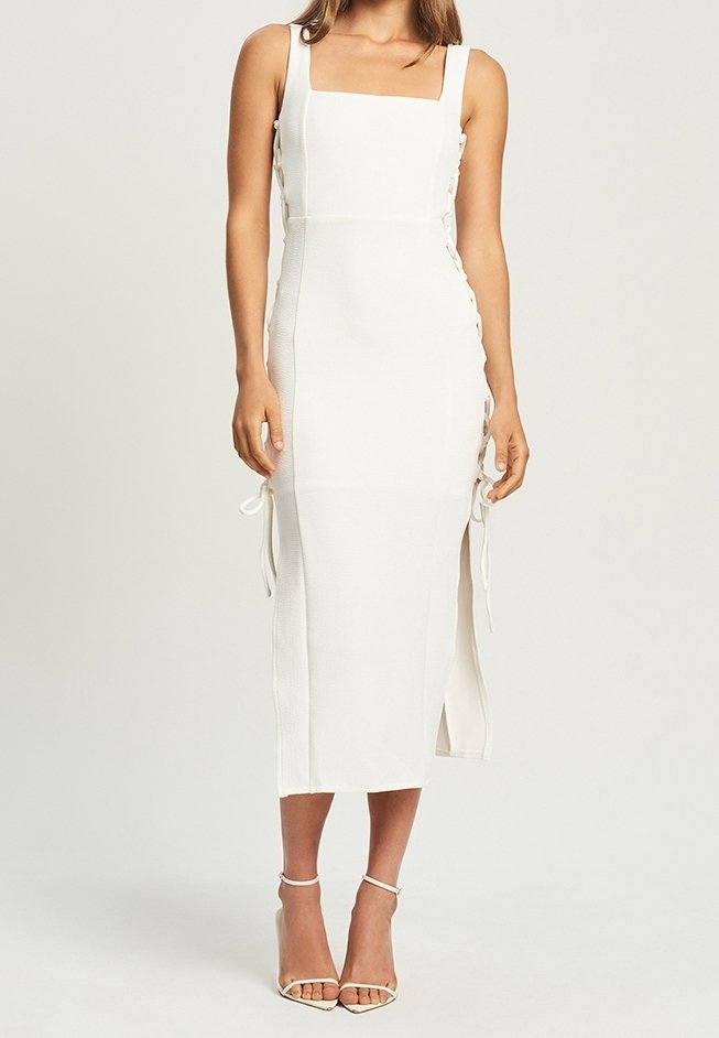 Robe midi blanche ajustée avec décolleté carré, fentes sur les côtés et rubans aux coutures, fabriquée à partir d'un tissu texturé. Fini lisse.