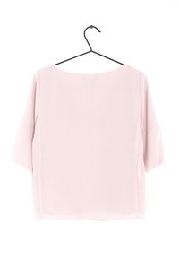 Losse lichtroze blouse met korte dolmanmouwen en een ronde halslijn. Gemaakt van een zachte, gladde stof met een iets doorzichtige achterkant.