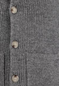 Szary sweter zapinany na guziki, z prążkowanym wykończeniem, pięcioma plastikowymi guzikami i dwiema przednimi kieszeniami. Projekt jest funkcjonalny i przytulny.